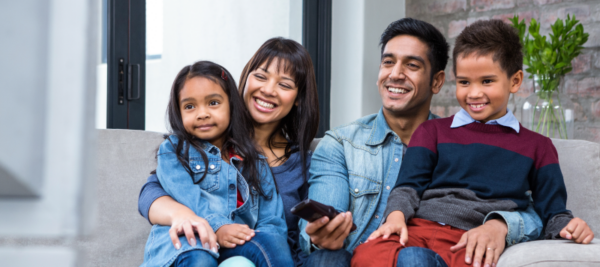 latino family watches TV on couch