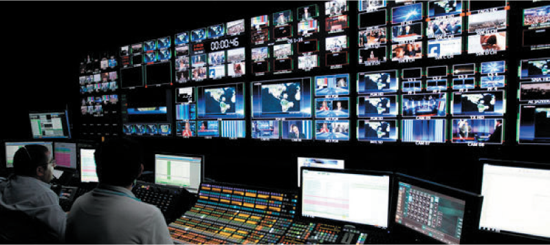 Image of TV broadcasting studio with wall of screens