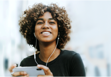 Lady smiling and listening to music with earphones