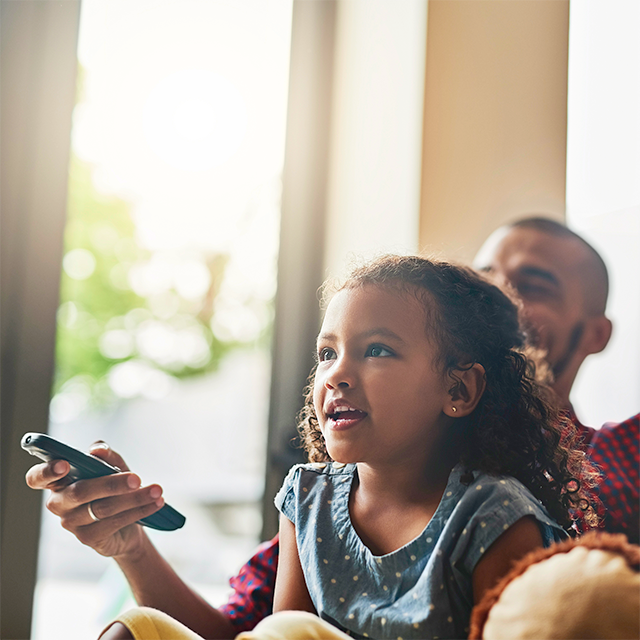 father and daughter watch tv together