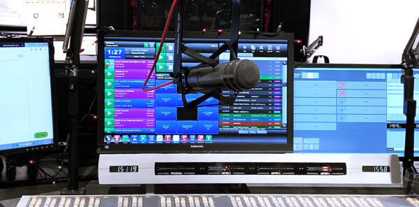 desktop screen with automation for radio software visible, and a microphone