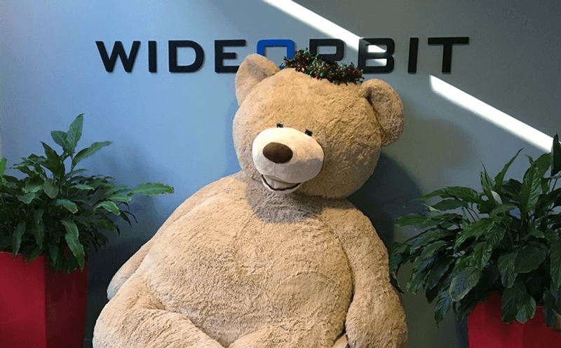 WideOrbit Teddy Bear against a wall with WideOrbit logo in San Francisco office